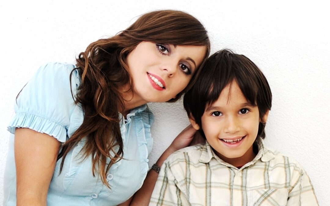 Young beautiful smiling woman and little boy sitting alogside ca